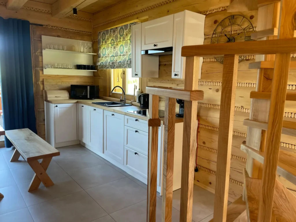 kuchnia w drewnianym domku z bali, schody na pierwsze piętro, jadalnia